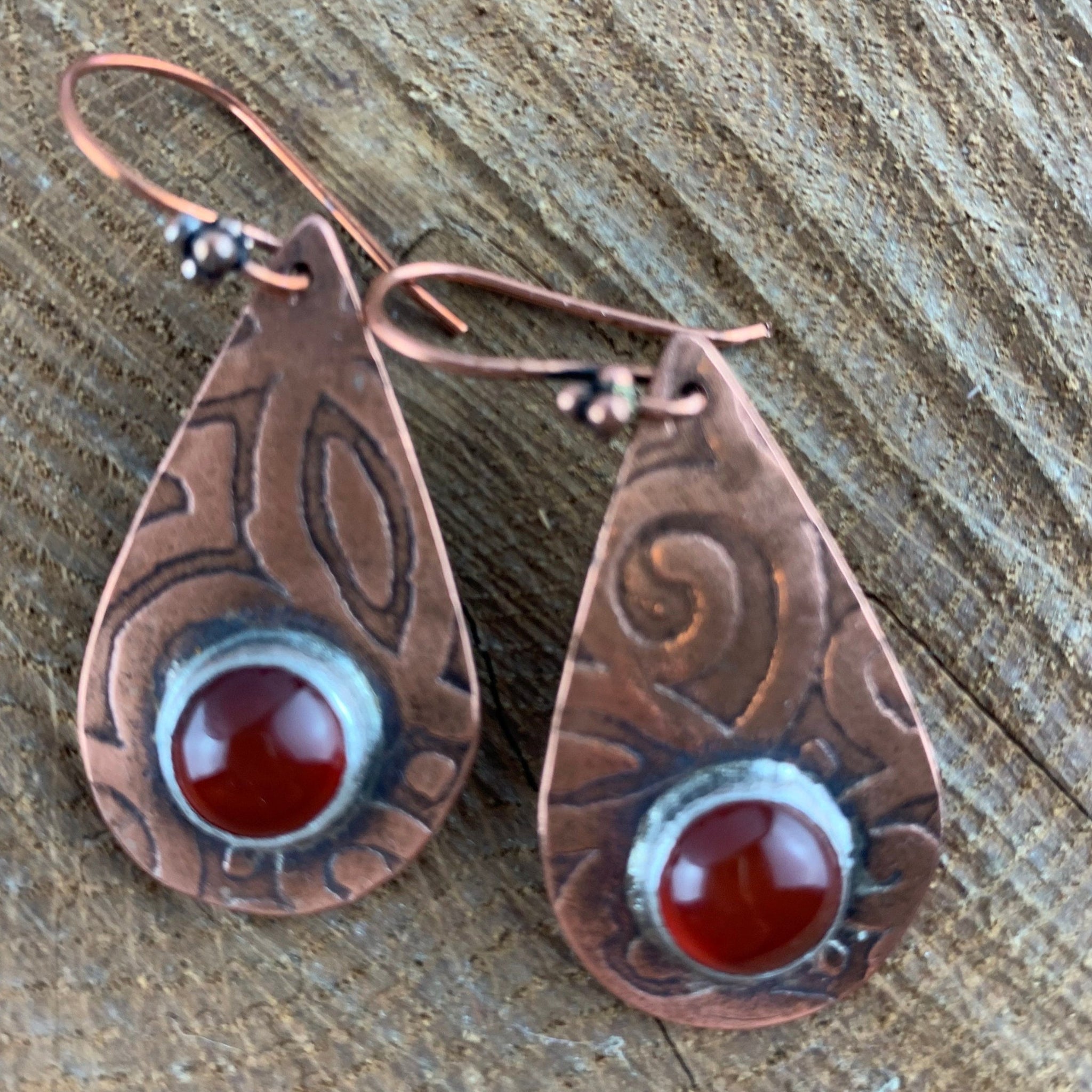 Antiqued and etched copper teardrop dangle earrings with a carnelian gemstone setting on French earwire.